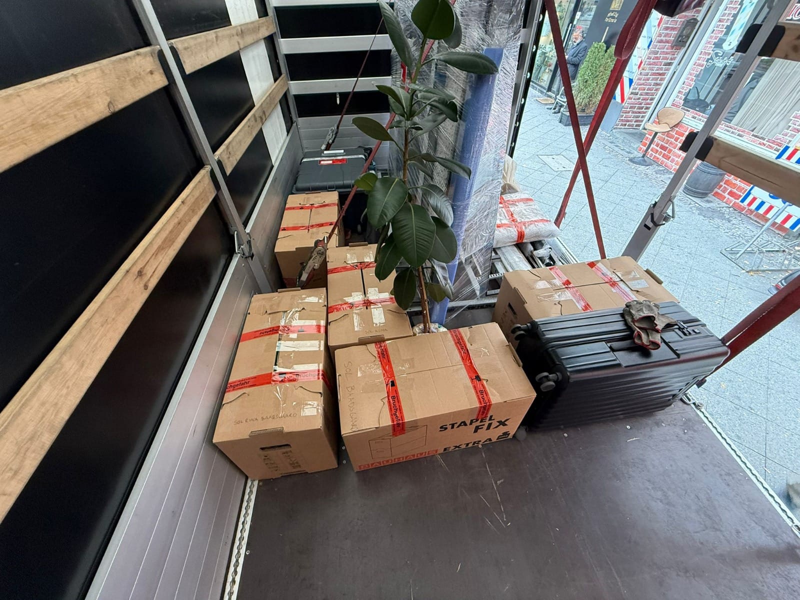 Moving boxes, luggage and wrapped belongings loaded into a removal vehicle