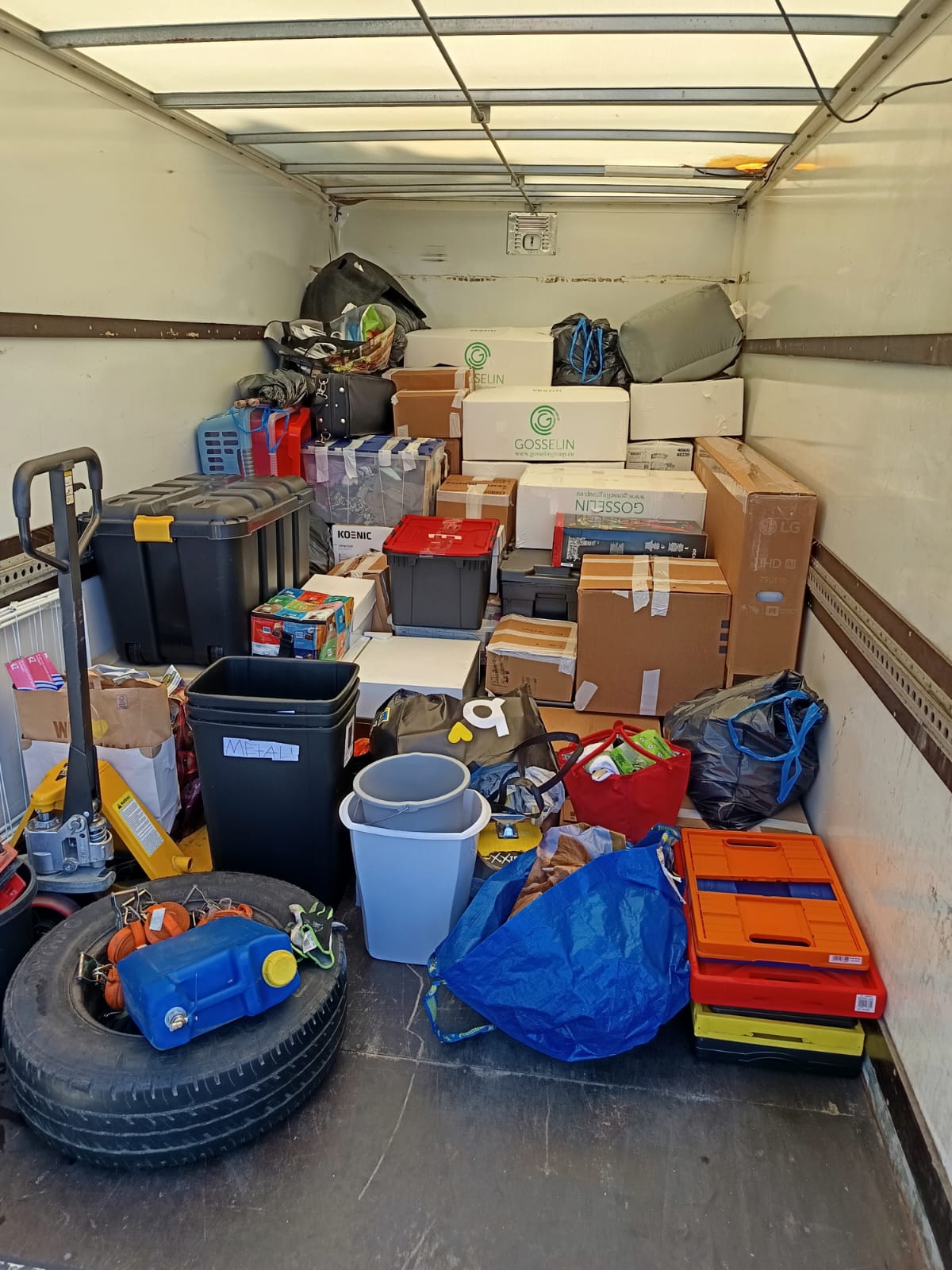 A truck loaded with boxes, containers and household belongings